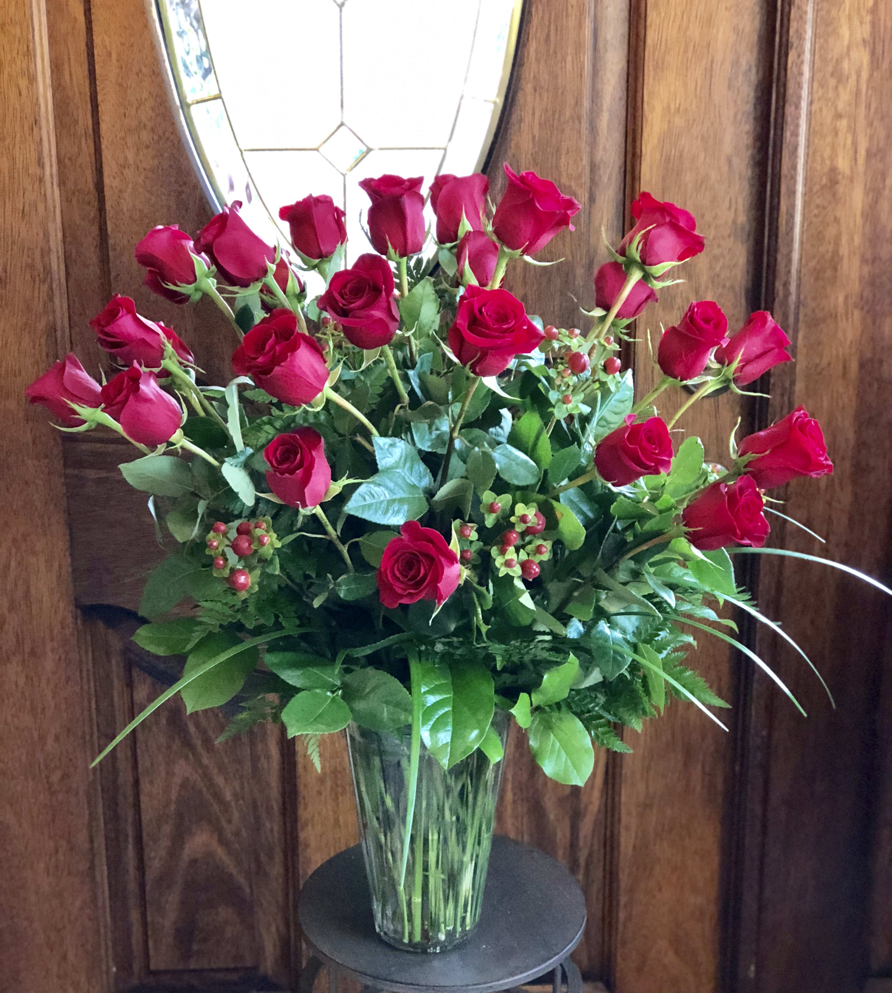 Red roses arranged in a clear glass vase