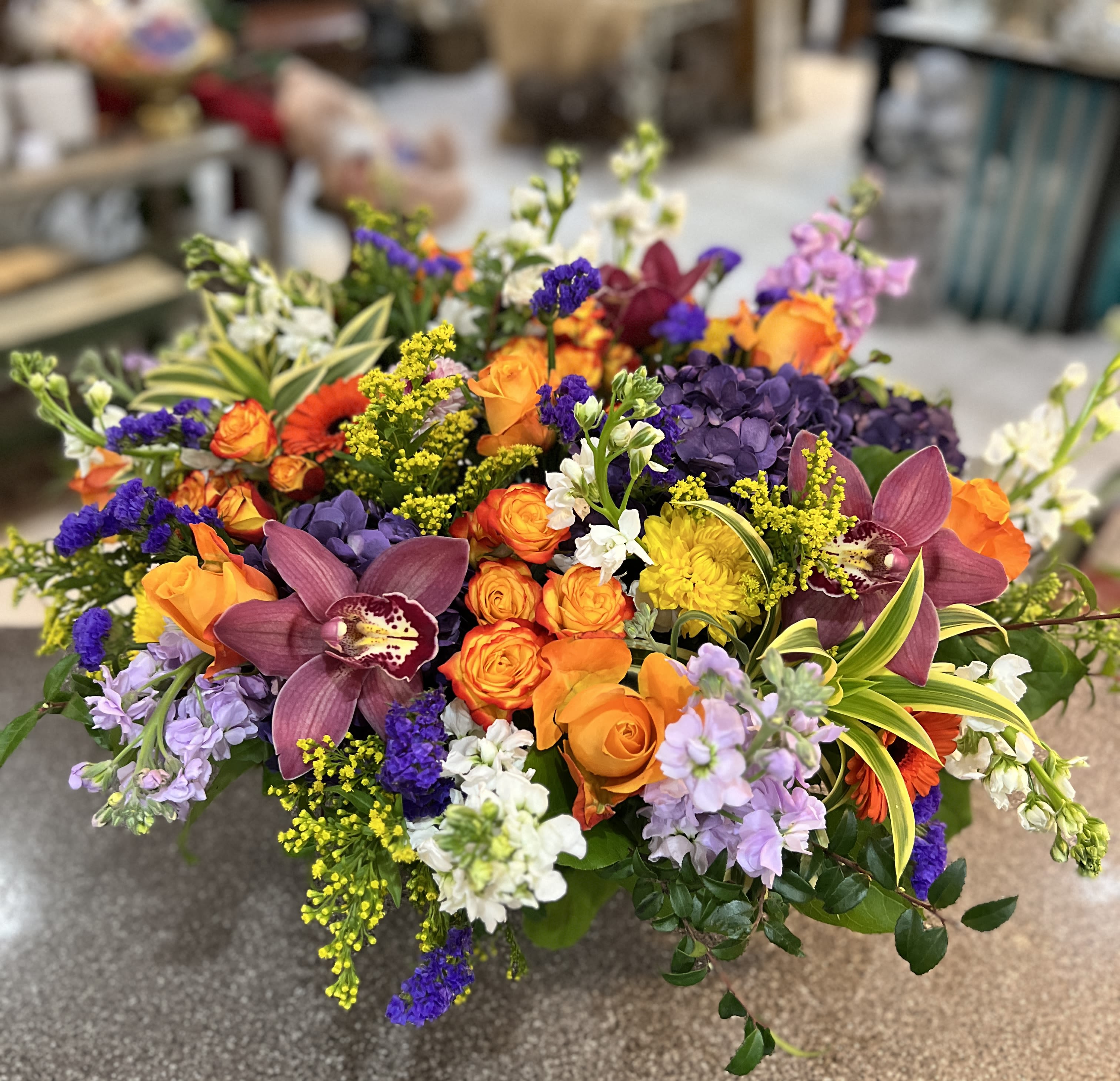 Colorful mixed bouquet with orange roses, purple orchids, and yellow accents