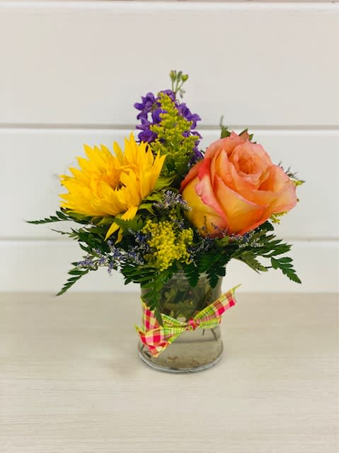 Small bouquet with a yellow sunflower and peach rose in a glass vase