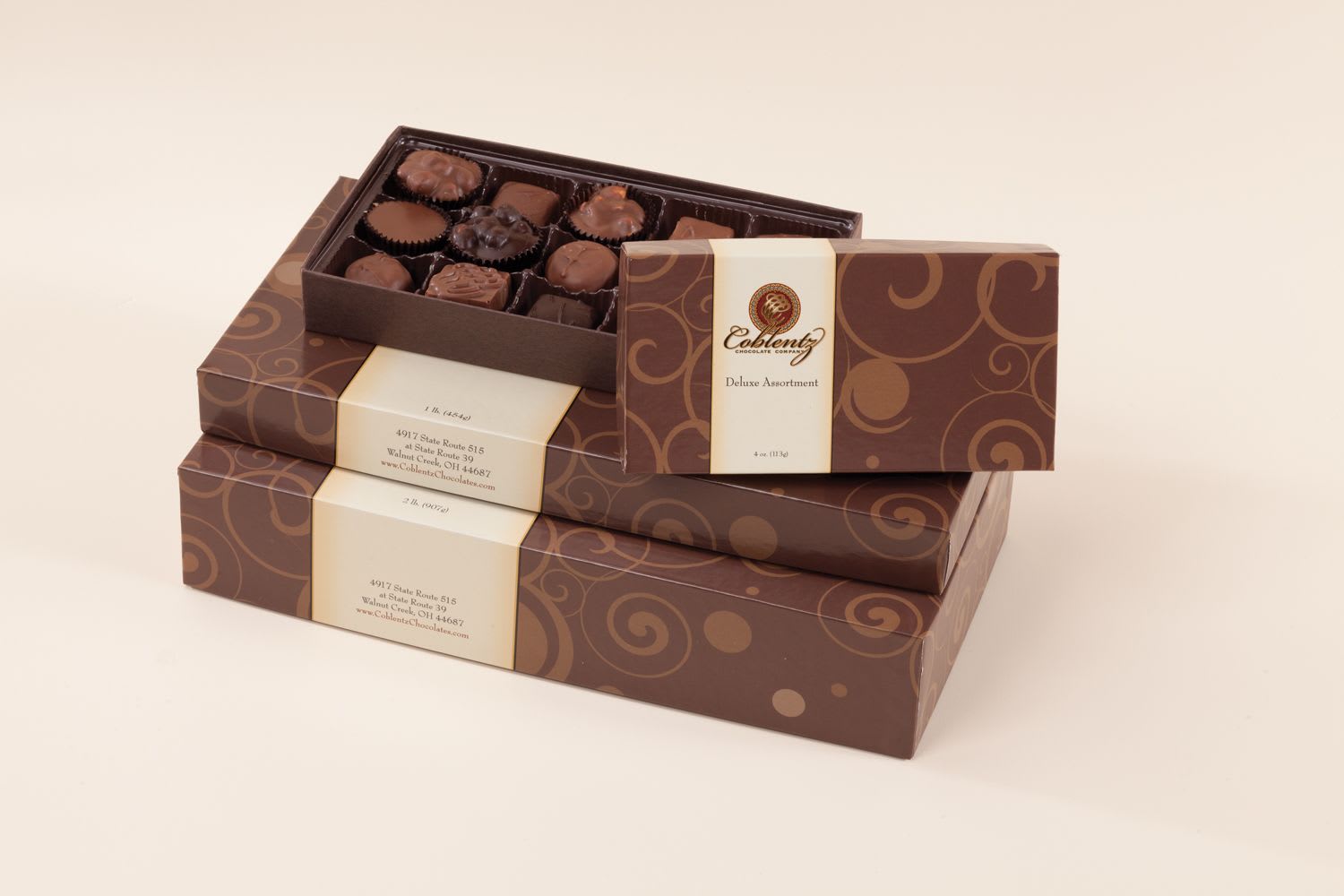 Stacked boxes of assorted chocolates with one open tray