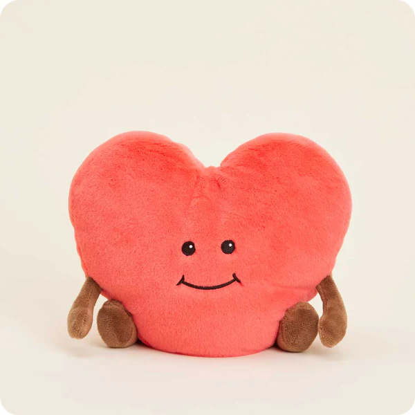Heart-shaped pink plush toy with a smiling face and small brown feet
