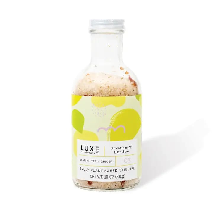 Bottle of jasmine tea and ginger bath soak with a colorful label