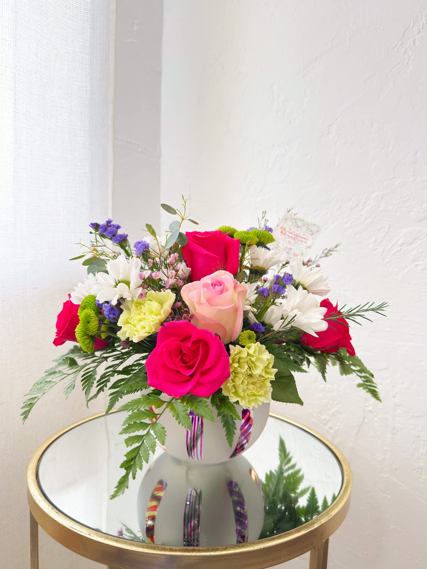 Mixed bouquet of pink and white roses with daisies in a white vase