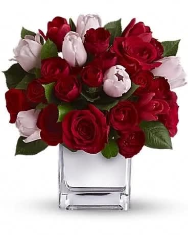 Red and white rose bouquet in a clear glass vase