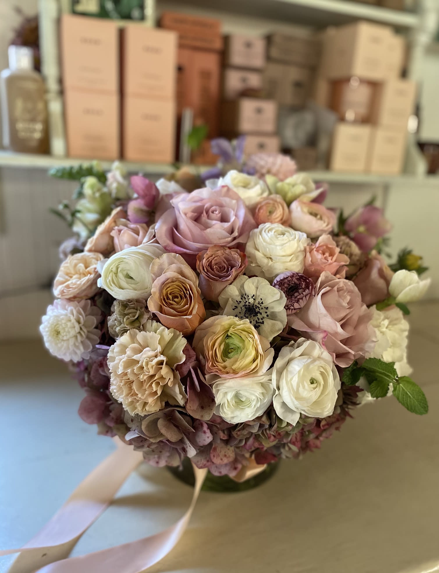 The Allure - Very elegant, classic and warm. This arrangement is a centerpiece style floral design, so it has a full circle style and can be viewed from all angles, with details going round it. Perfect for the table setting but also just beuatiful as a gift. Packed with seasonal stems of fall and golden light. Arranged in a 6" by 6" clear vase. Choose Deluxe and Premium for more stems.