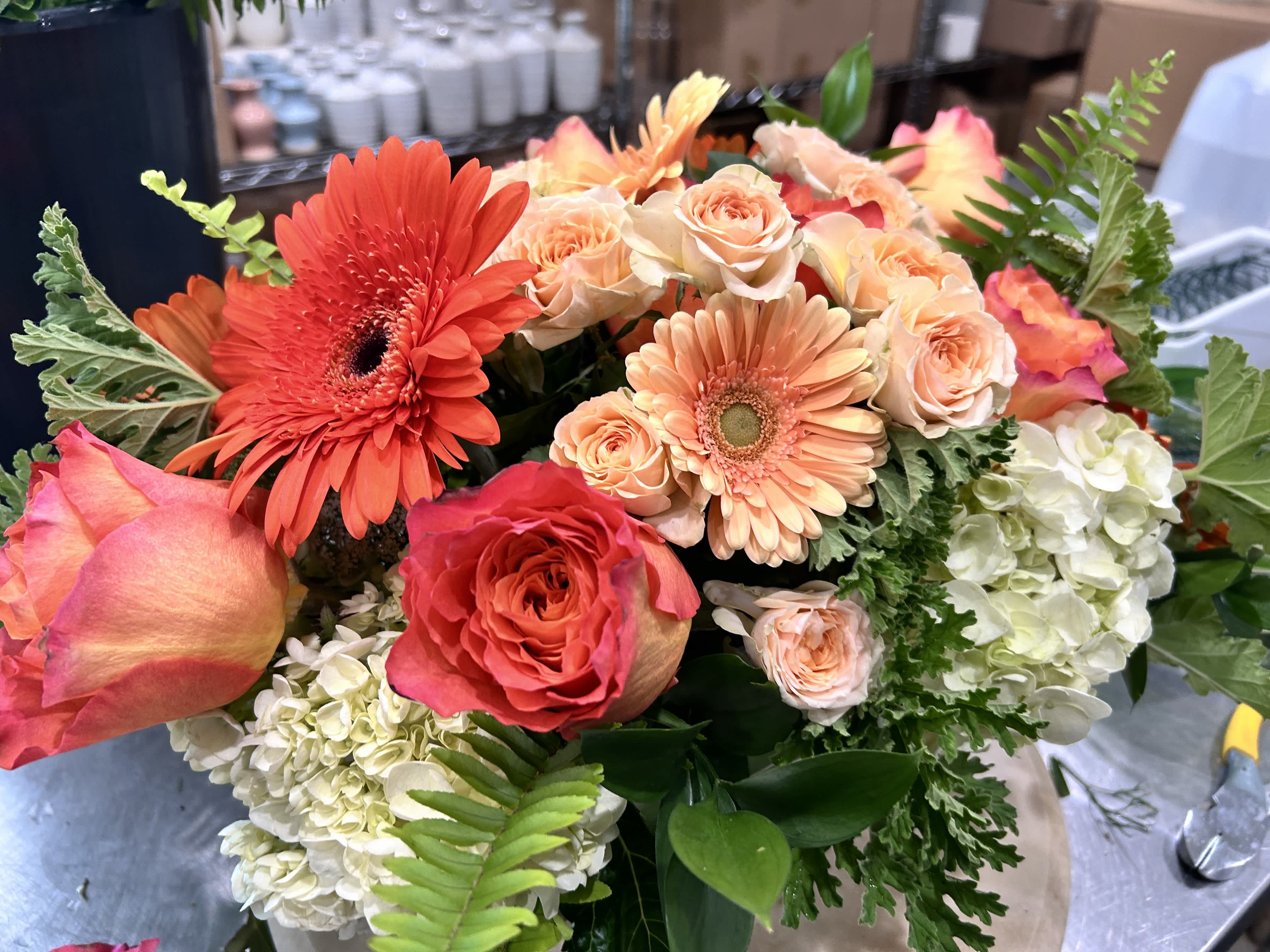 Large bouquet of peach and coral roses with orange gerbera daisies