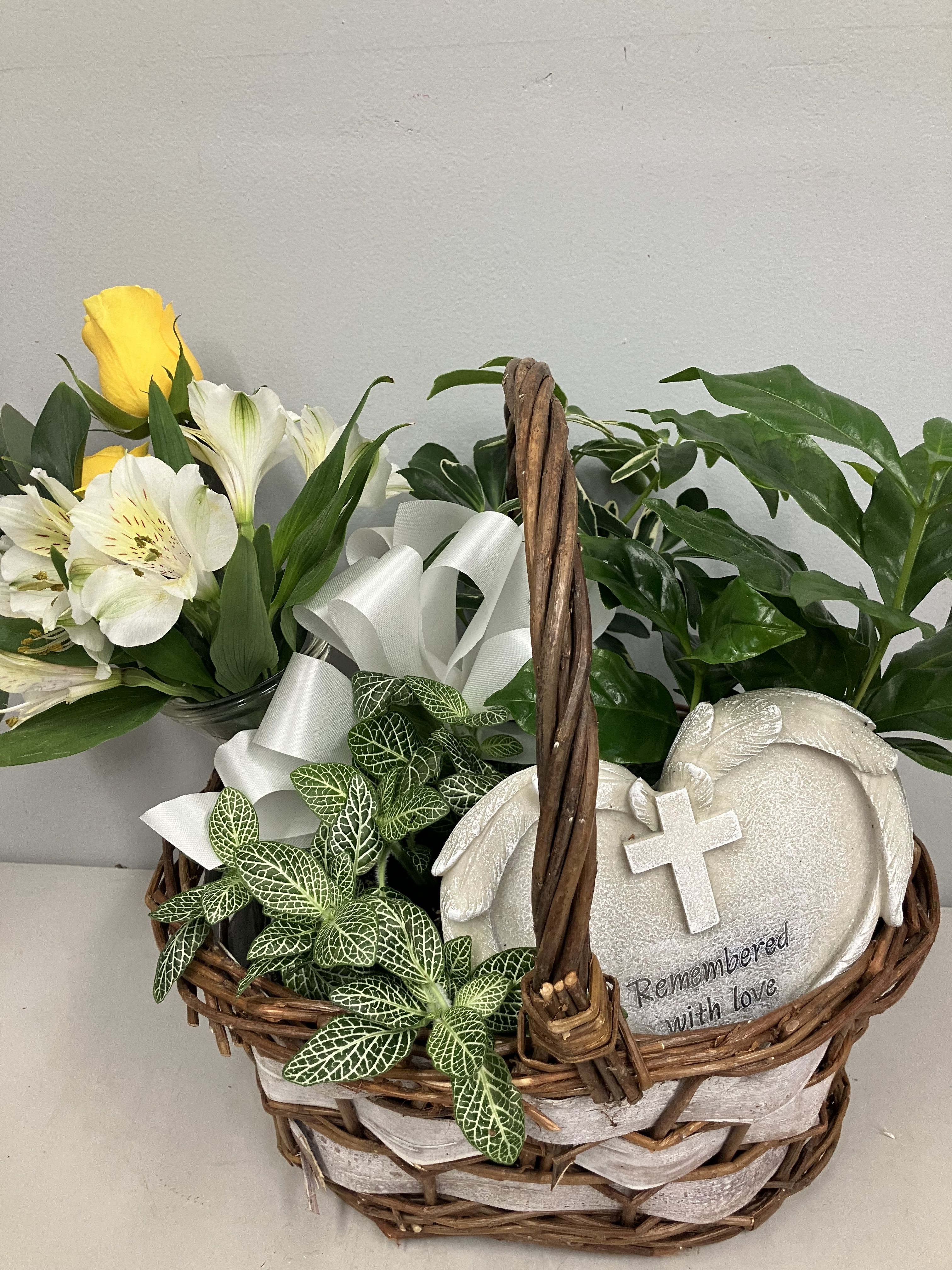 Basket arrangement with yellow and white flowers and a memorial plaque
