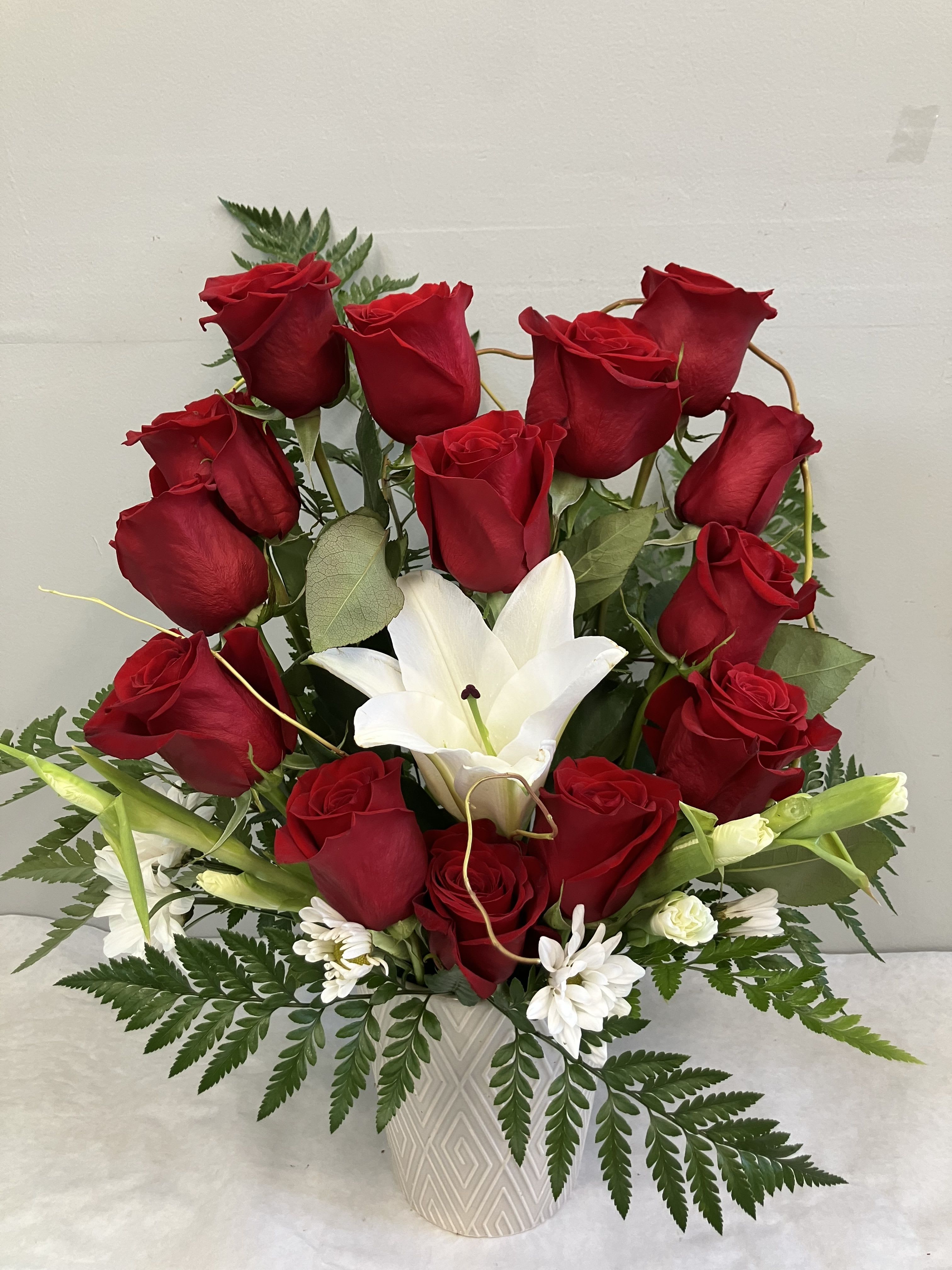 Red roses and white lilies arranged in a white vase