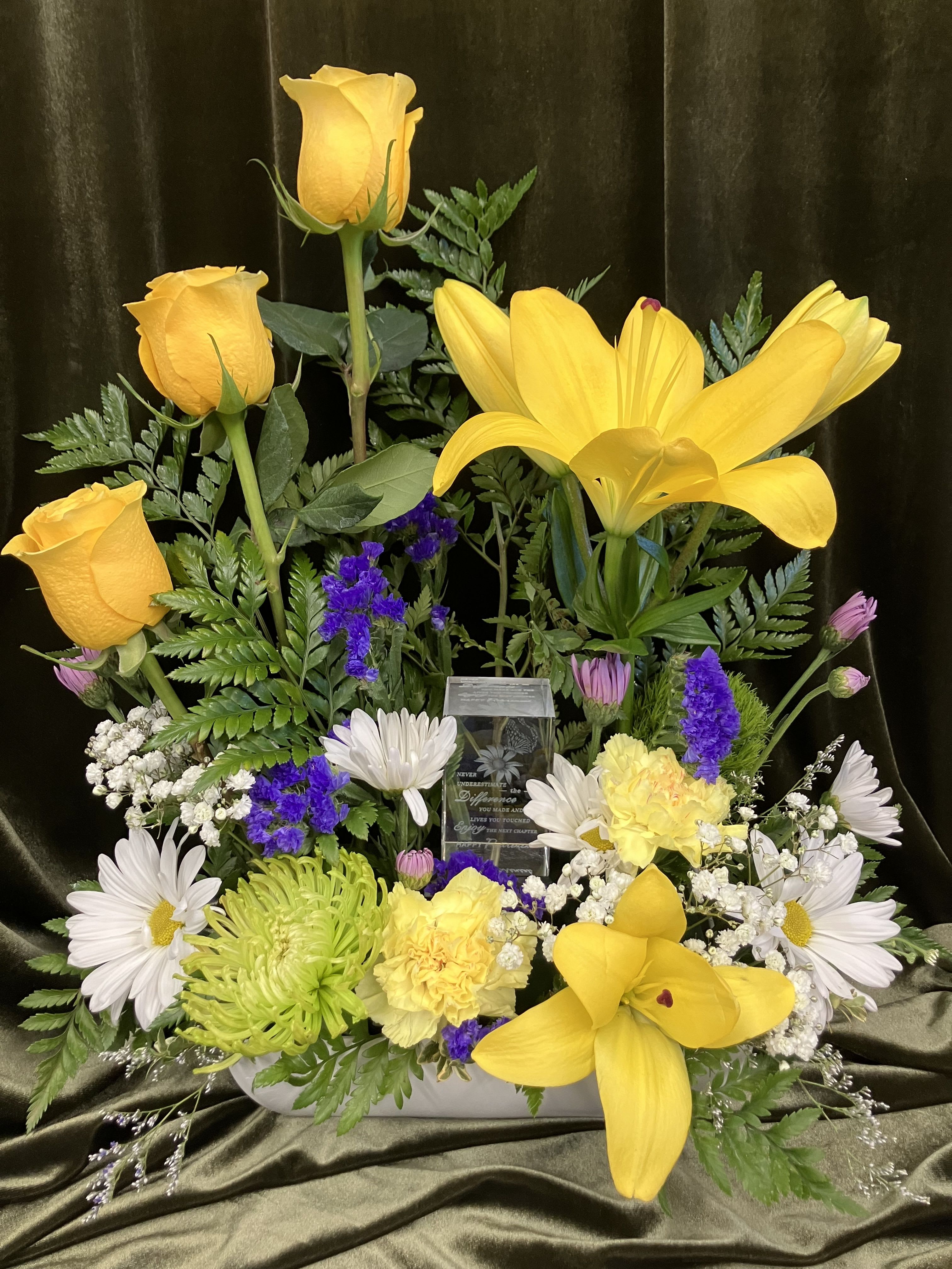 Yellow roses and lilies with white daisies in a low arrangement