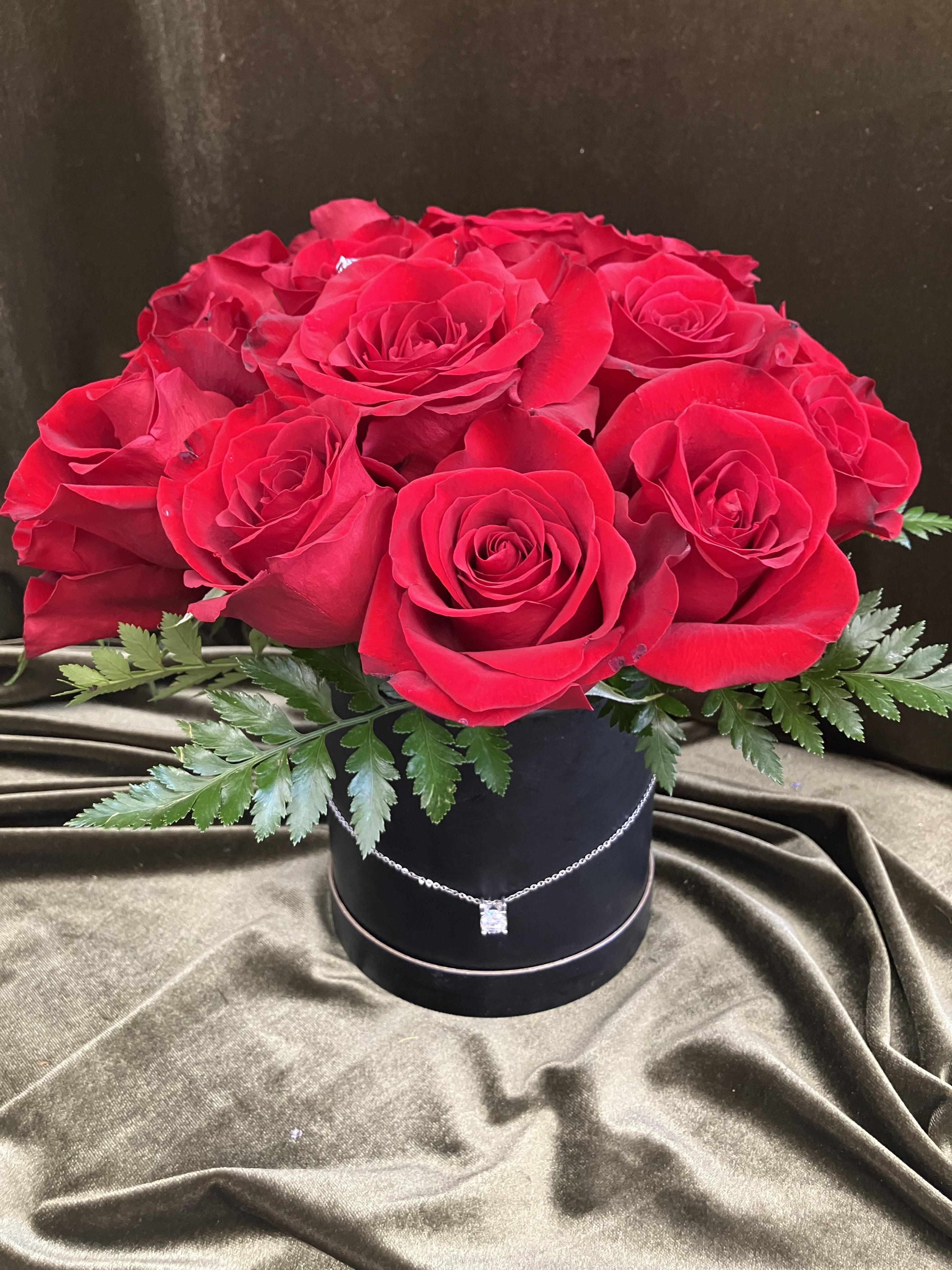 Red Rose Barrel Arrangement  - Twenty four red roses arranged tightly in a classy black barrel, beautifully displayed with an earring and necklace gift. 