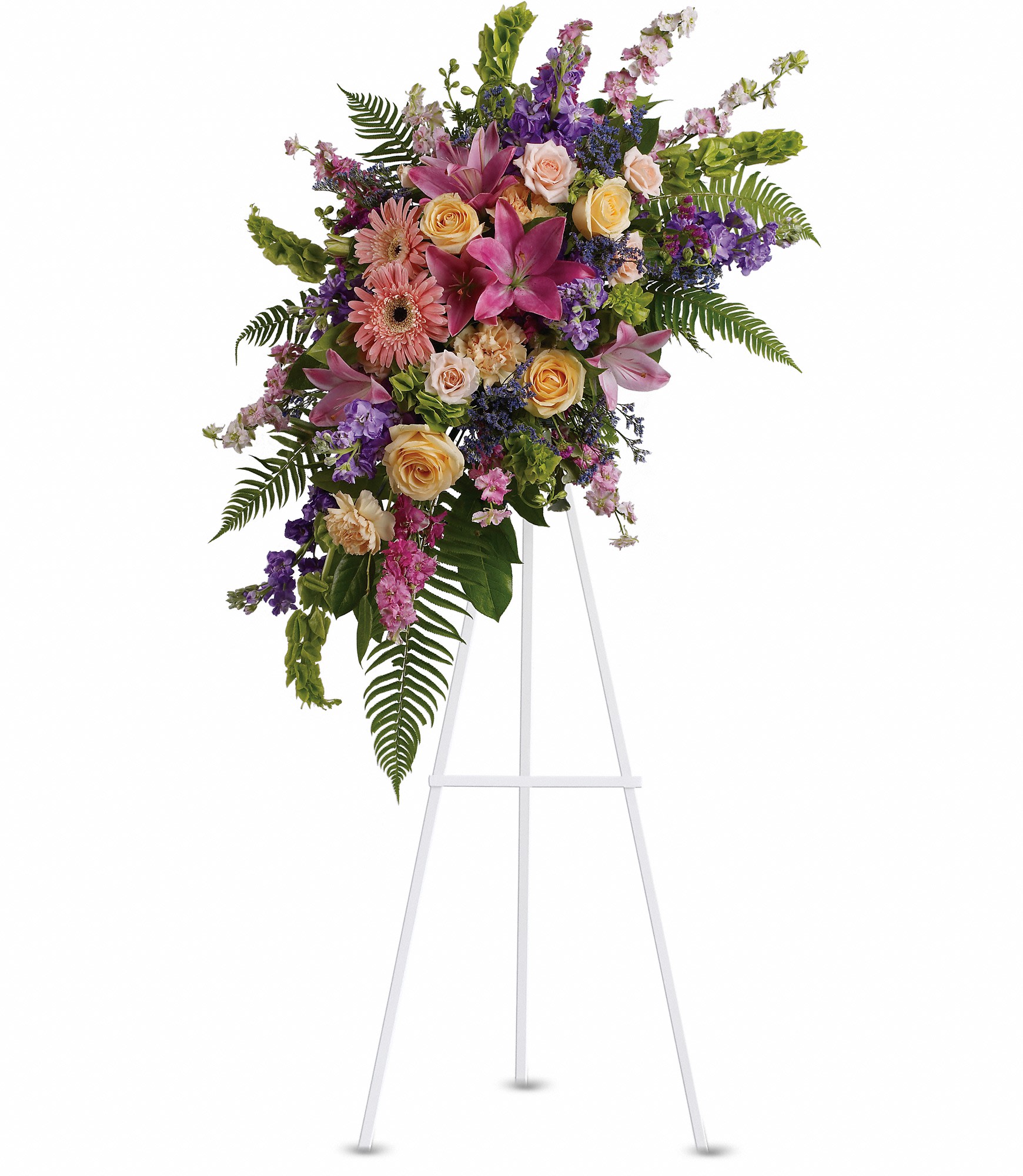 Tall standing spray of pink lilies, roses, and mixed blooms on a white easel