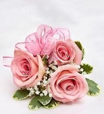 Small cluster of pink roses with white filler flowers and a pink ribbon bow