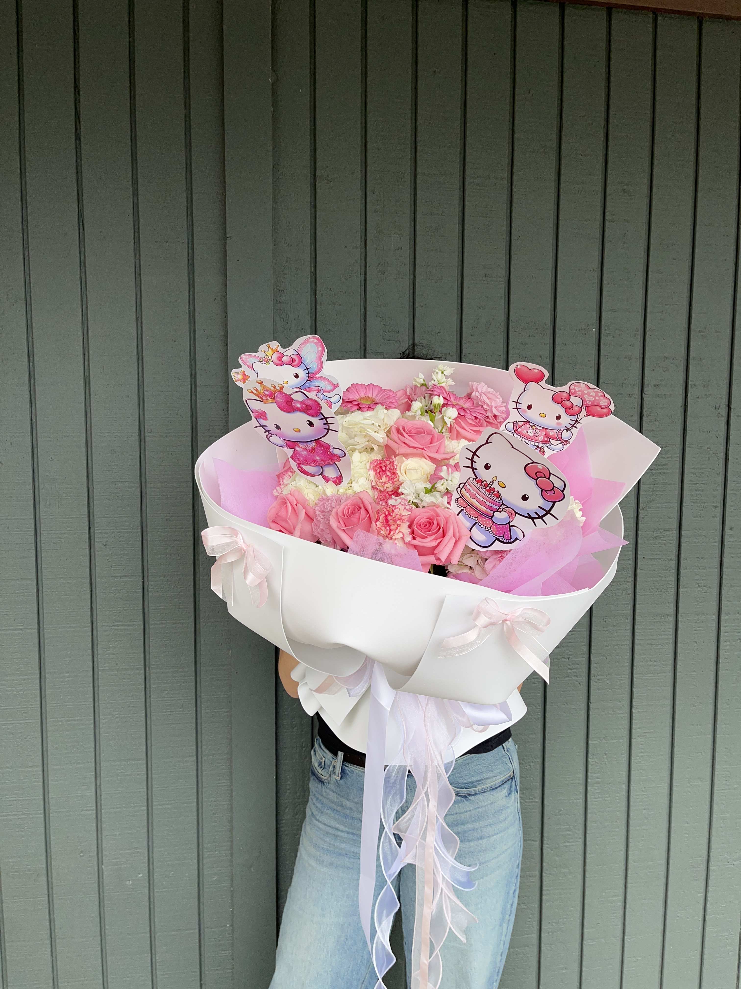 Pink and white bouquet with Hello Kitty toppers in a white wrap