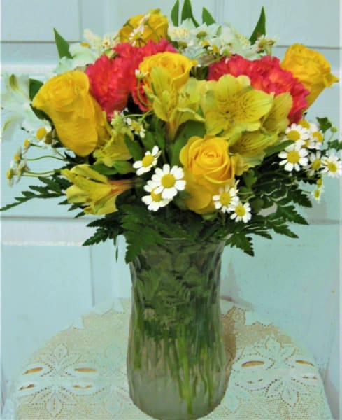Bouquet of yellow and red flowers in a clear glass vase