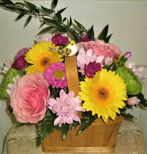 Basket arrangement with pink and yellow flowers and greenery