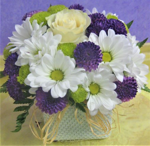 Bouquet of white daisies, purple blooms, and a pale yellow rose