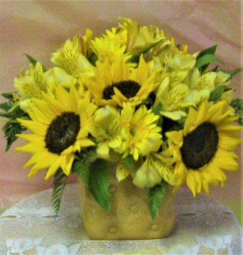 Bouquet of yellow sunflowers and alstroemeria in a gold vase
