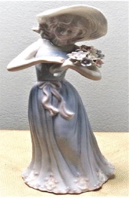 Ceramic figurine of a girl holding a small bouquet of flowers