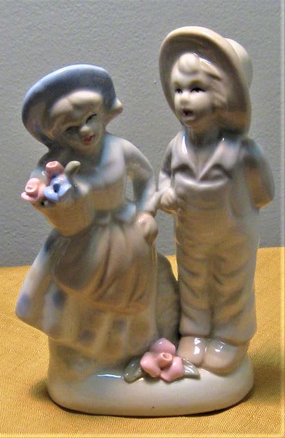 Ceramic figurine of two children holding small flower baskets