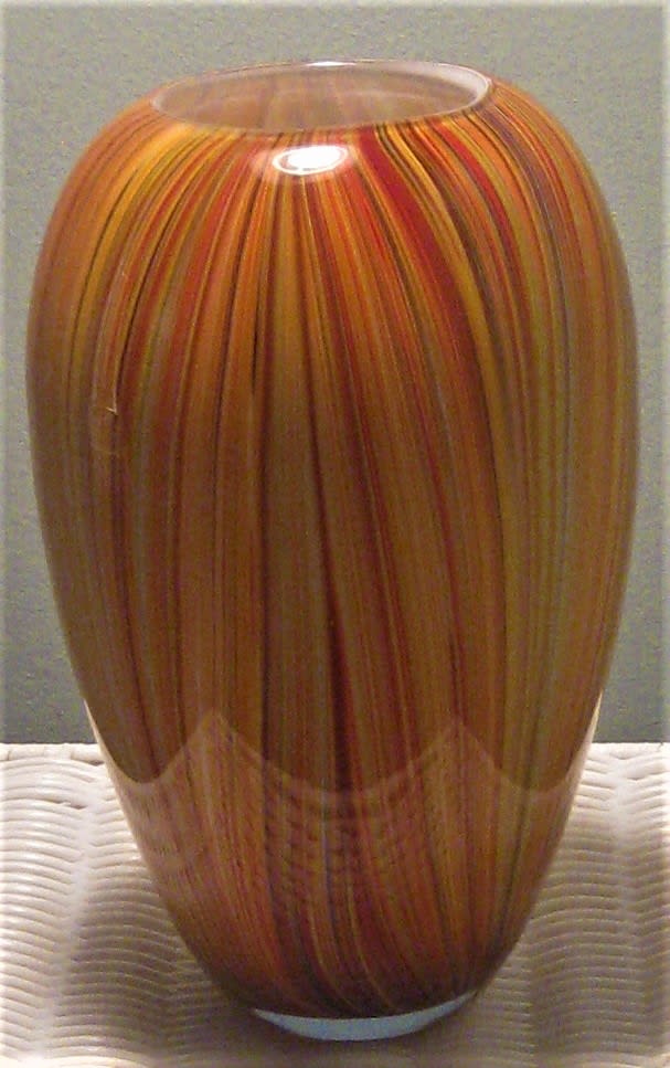 Tall striped glass vase in orange, red, and yellow tones