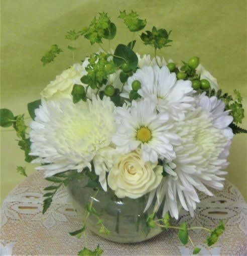 White daisies and roses arranged in a glass vase