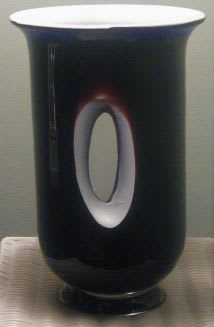 Black cylindrical vase with a white oval opening detail