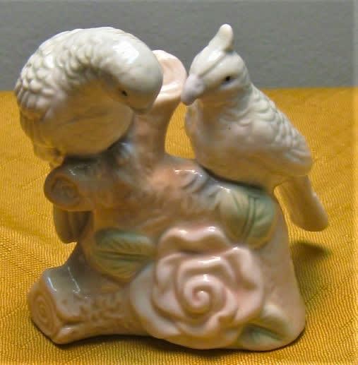 Ceramic bird figurine on a floral base