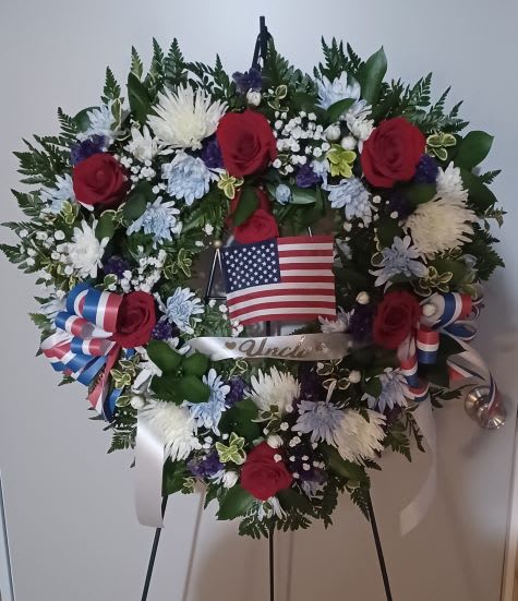 Heart-shaped floral wreath with red roses and an American flag
