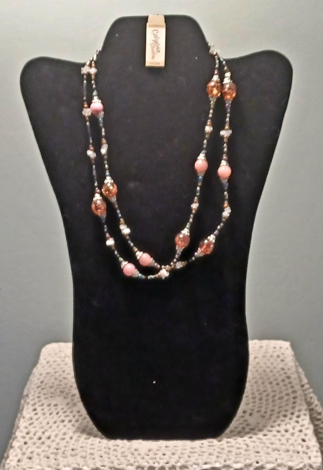 Beaded necklace displayed on a black bust stand