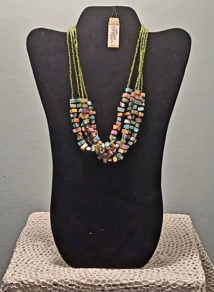 Multistrand beaded necklace on a black display bust