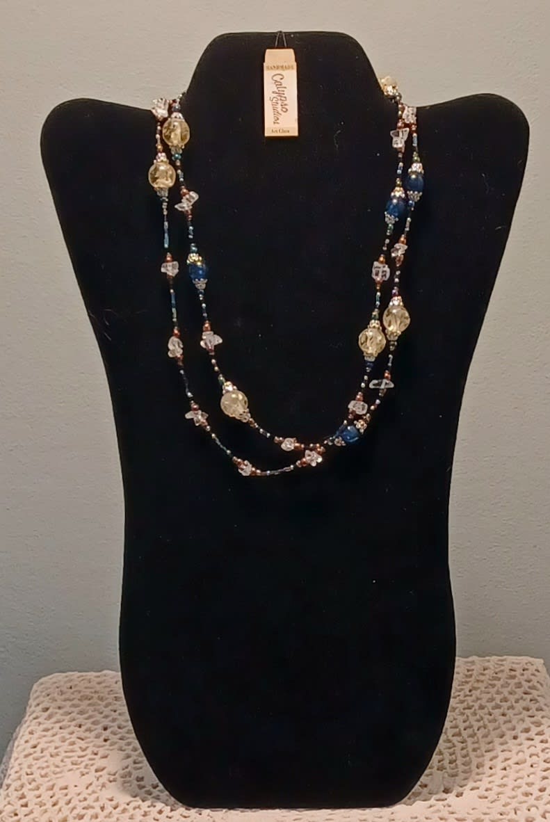 Beaded necklace displayed on a black bust stand