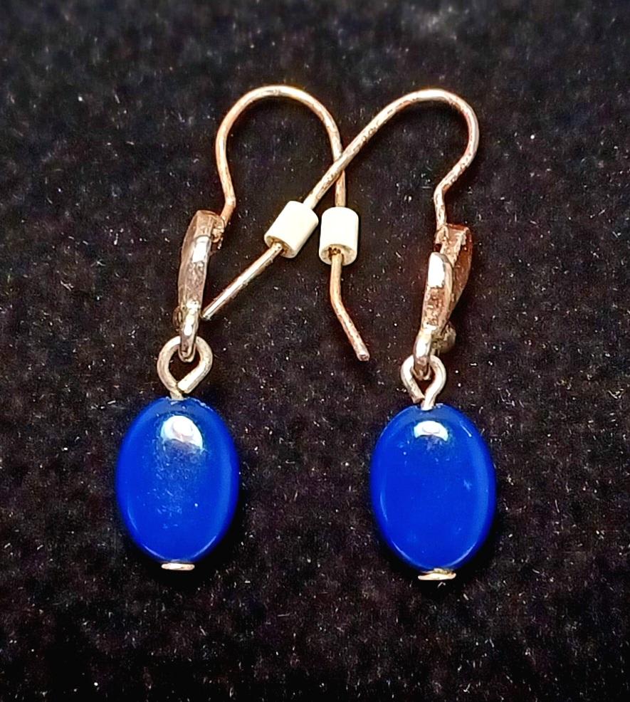 Pair of blue oval drop earrings on a dark background
