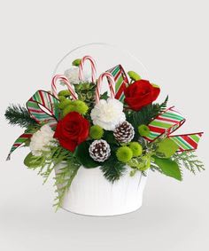 Holiday bouquet with red and white roses in a white container