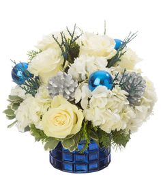 White roses and hydrangeas in a blue glass vase with blue ornaments