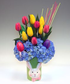 Bouquet of yellow and pink tulips in a bunny-decorated vase