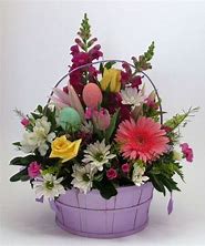 Mixed flower basket with pastel eggs in a lavender container
