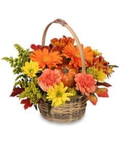 Basket of orange, yellow, and pink flowers with a handle