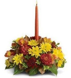 Autumn floral centerpiece with a tall orange taper candle