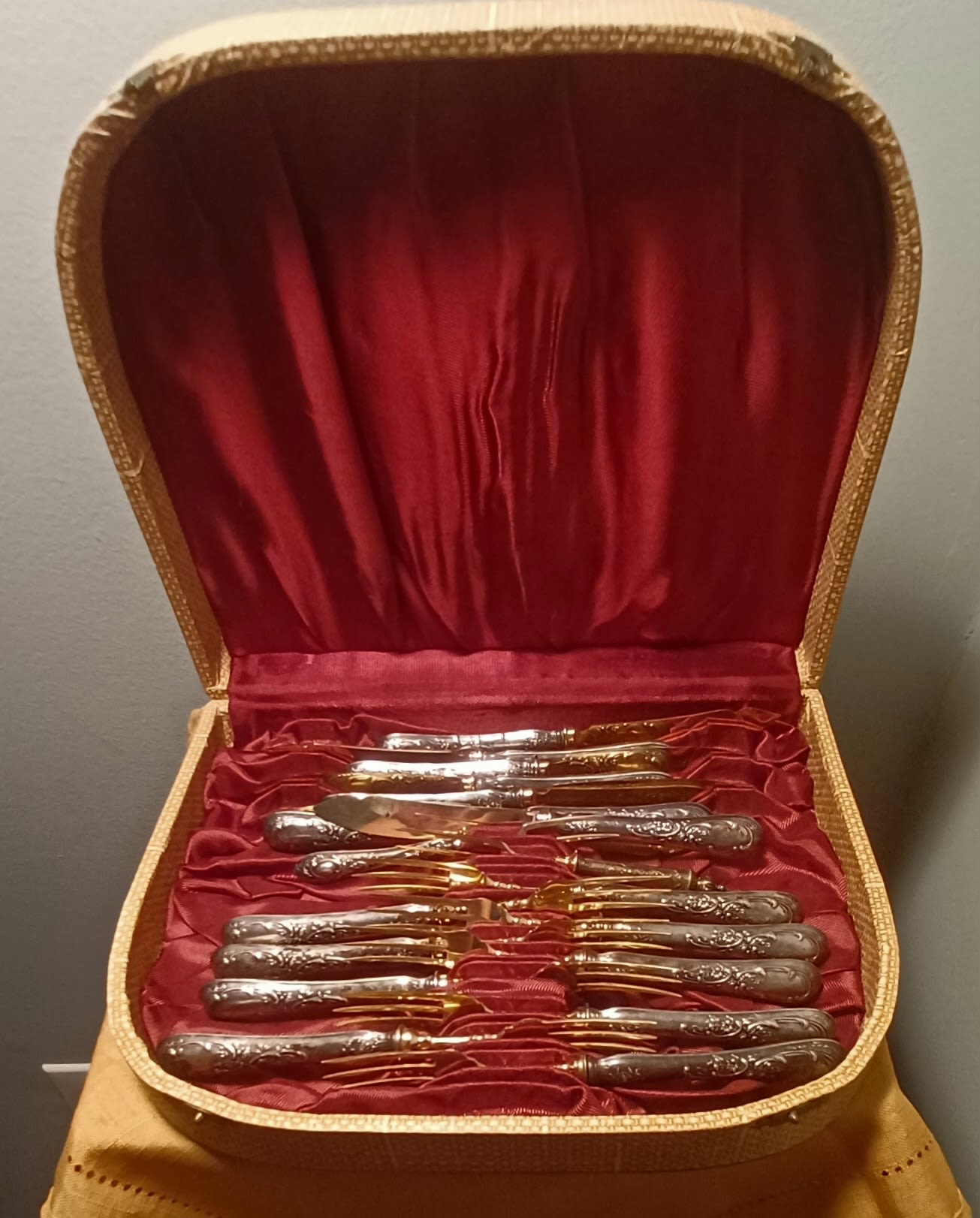 Open case holding a set of silver and gold flatware
