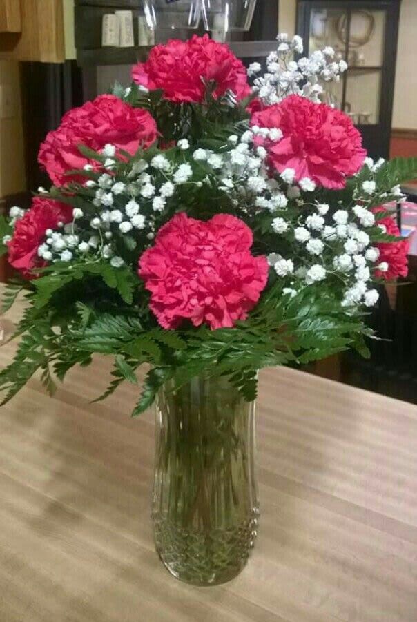 Pink carnations and white baby's breath in a clear glass vase