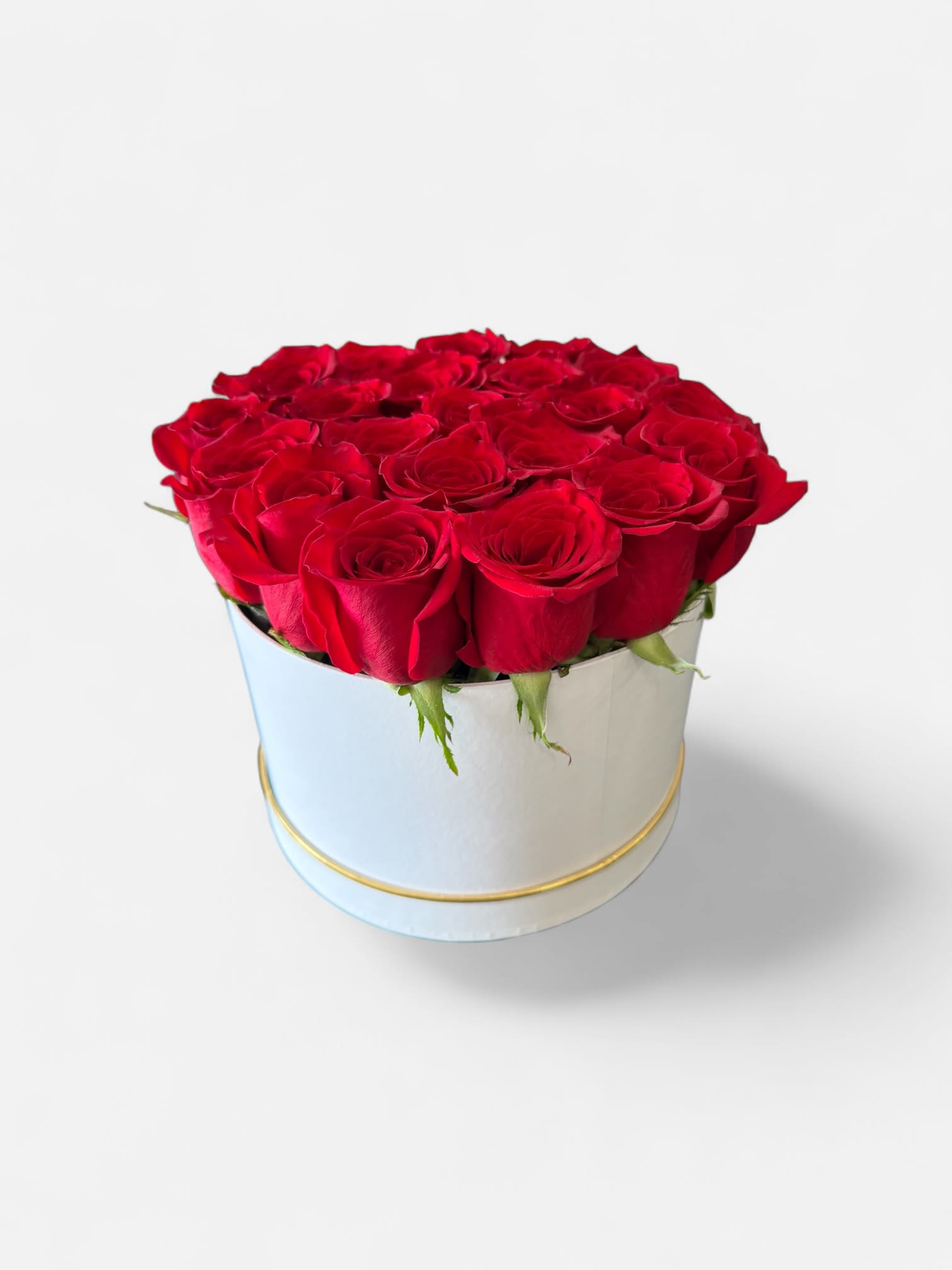 Red roses arranged in a round white hat box