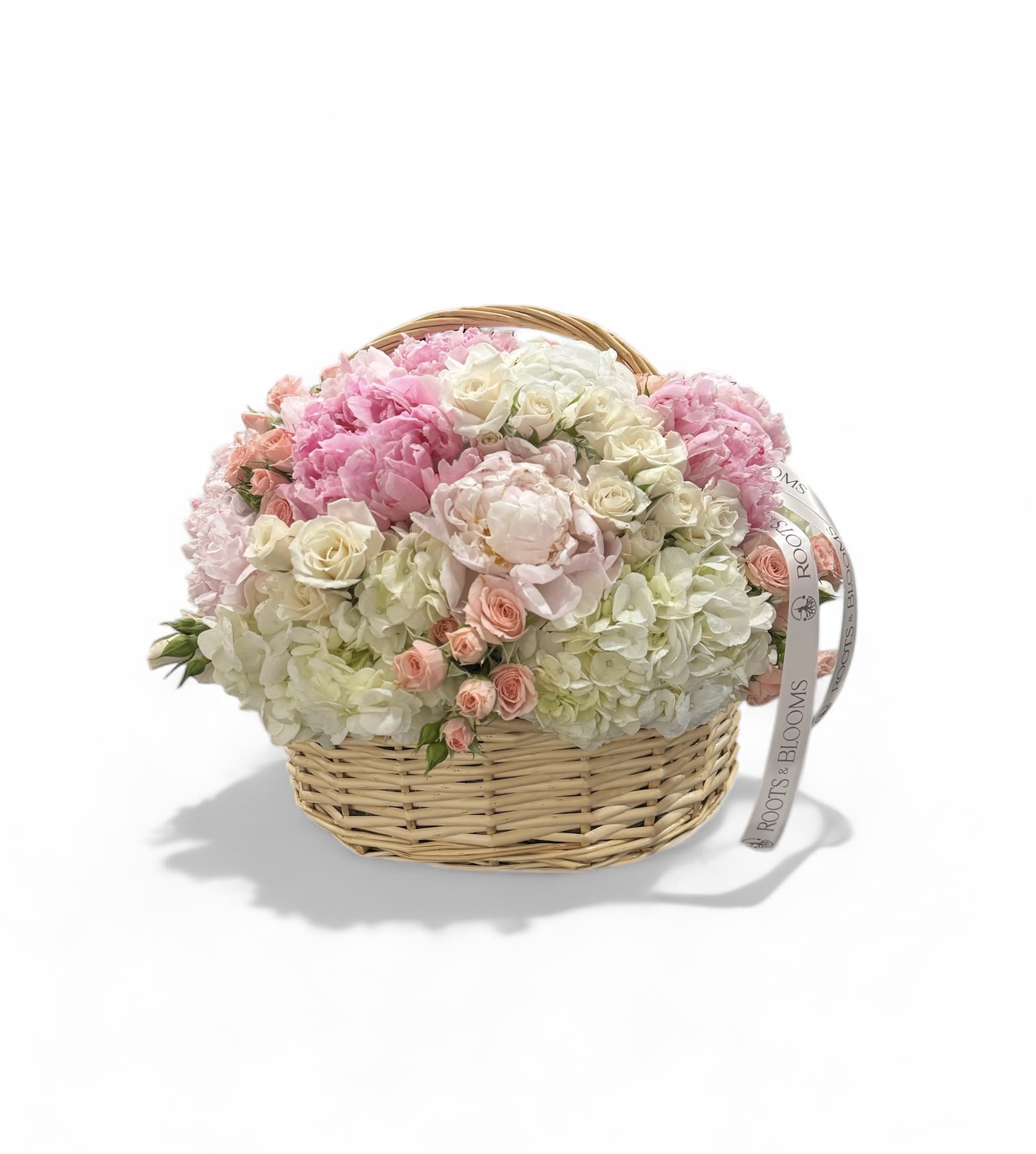 Pink and white flower arrangement in a wicker basket