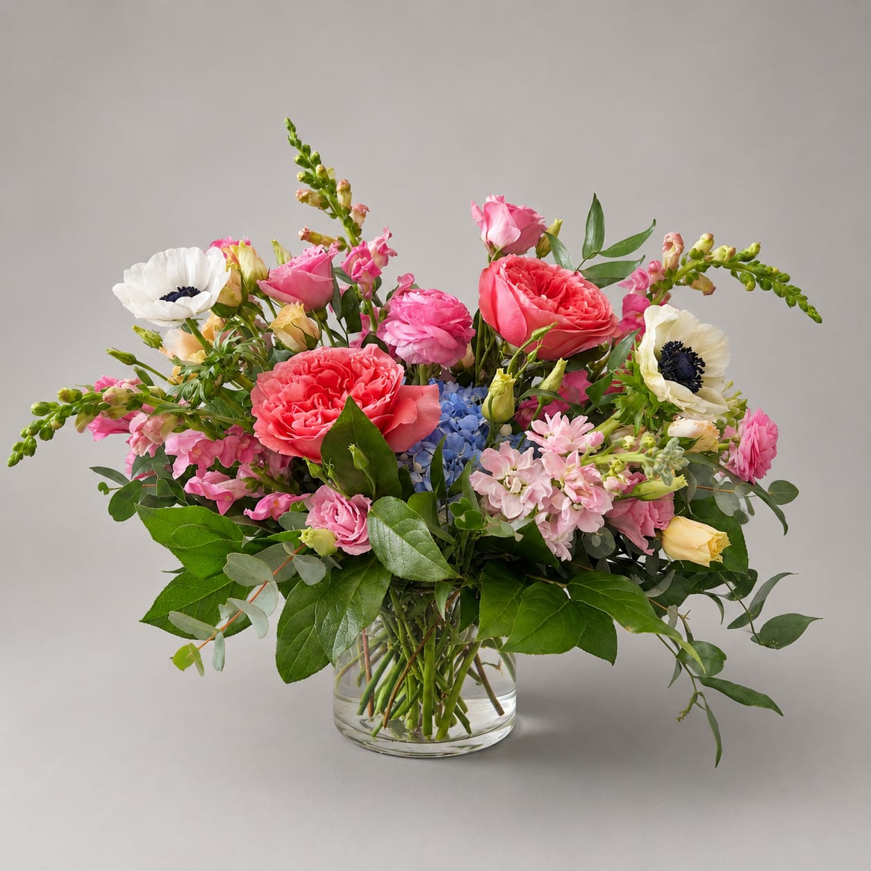 Mixed pink and white flower arrangement in a clear glass vase