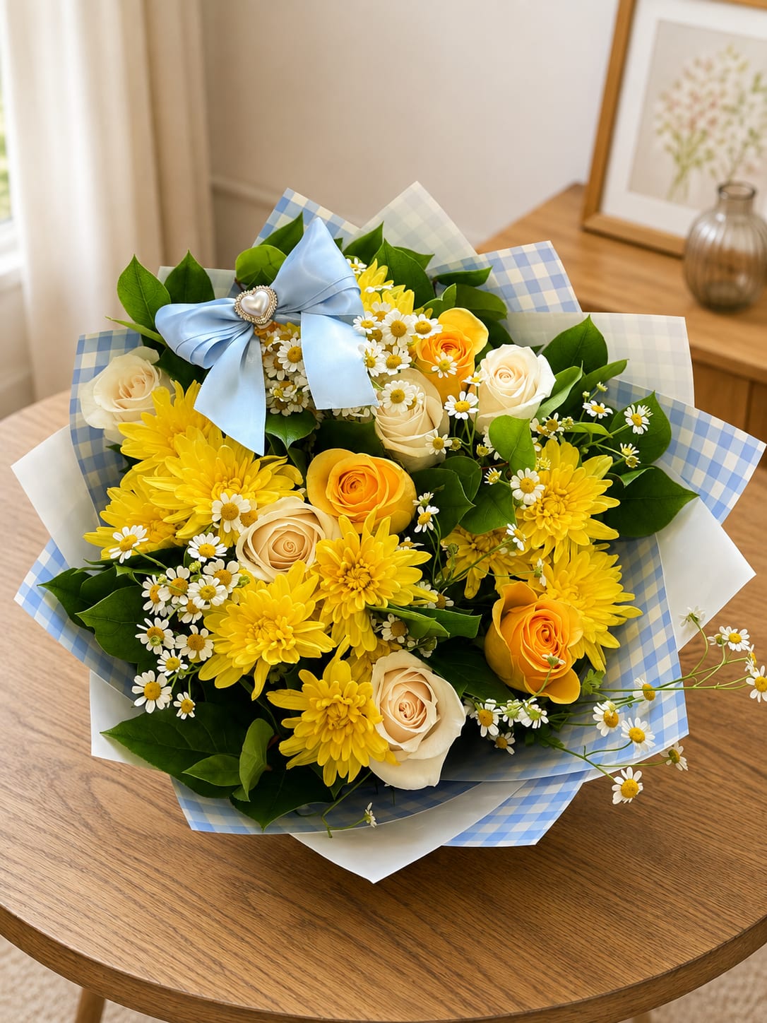 Bouquet of yellow and cream roses with small white daisies and a blue ribbon