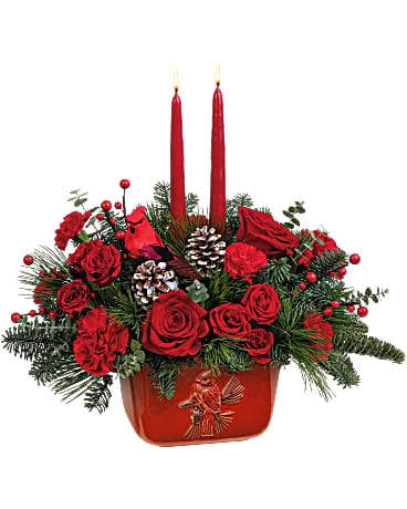 Teleflora's Winter's Flight Centerpiece - Embossed with a nostalgic cardinal motif and hand-painted a radiant crimson red, this food-safe stoneware dish with handles serves up a classic Christmas centerpiece today, and delicious dishes for years to come! Red roses, red spray roses, red carnations and miniature red carnations are arranged with spiral eucalyptus, noble fir, white pine and two red candles. Delivered in a Classic Cardinal Bowl.