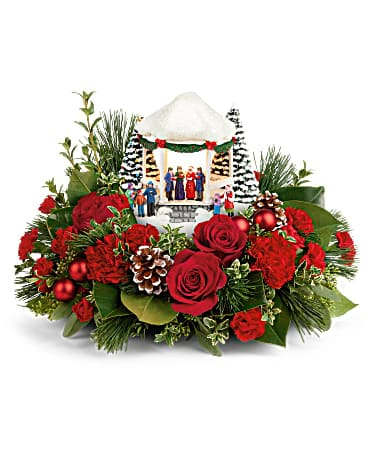 Thomas Kinkade's Sweet Sounds Of Christmas - Spread holiday cheer with this classic, hand-painted Thomas Kinkade collectible, featuring joyful carolers under a light-up gazebo, nestled among Christmas roses and greens. This festive arrangement features red roses, red carnations, miniature red carnations, white pine, magnolia leaves, oregonia, seeded eucalyptus and lemon leaf. Delivered with a Thomas Kinkade's Sweet Sounds of Christmas Keepsake.