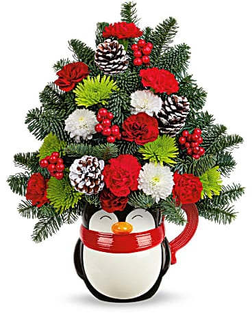 Teleflora's Send A HugÂ® Warm Wisher Tree - Whether bursting with a festive floral Christmas tree or serving up hot cocoa on Christmas morning, this jolly ceramic penguin mug is a merry must-have for holiday celebrations! This bouquet features miniature maroon carnations, miniature red carnations, white button spray chrysanthemums, green cushion spray chrysanthemums and noble fir. Delivered in a North Pole Penguin Mug.