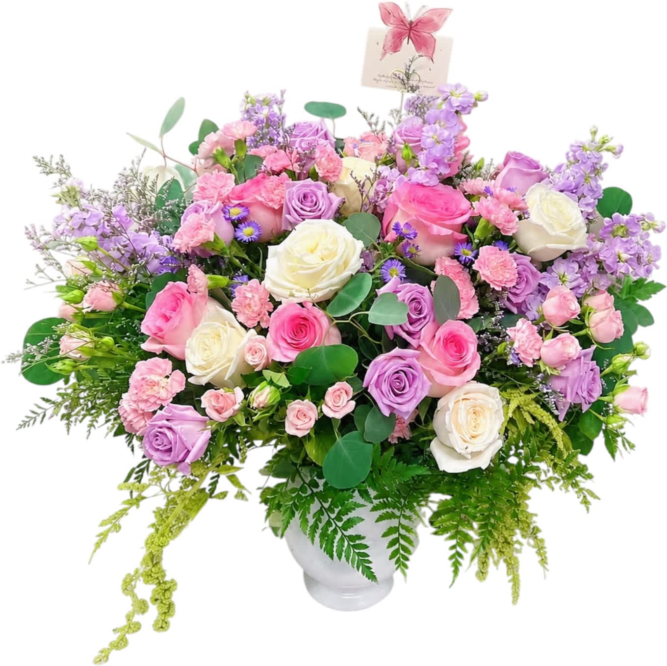 Large pastel bouquet of roses, carnations, and purple flowers in a white vase