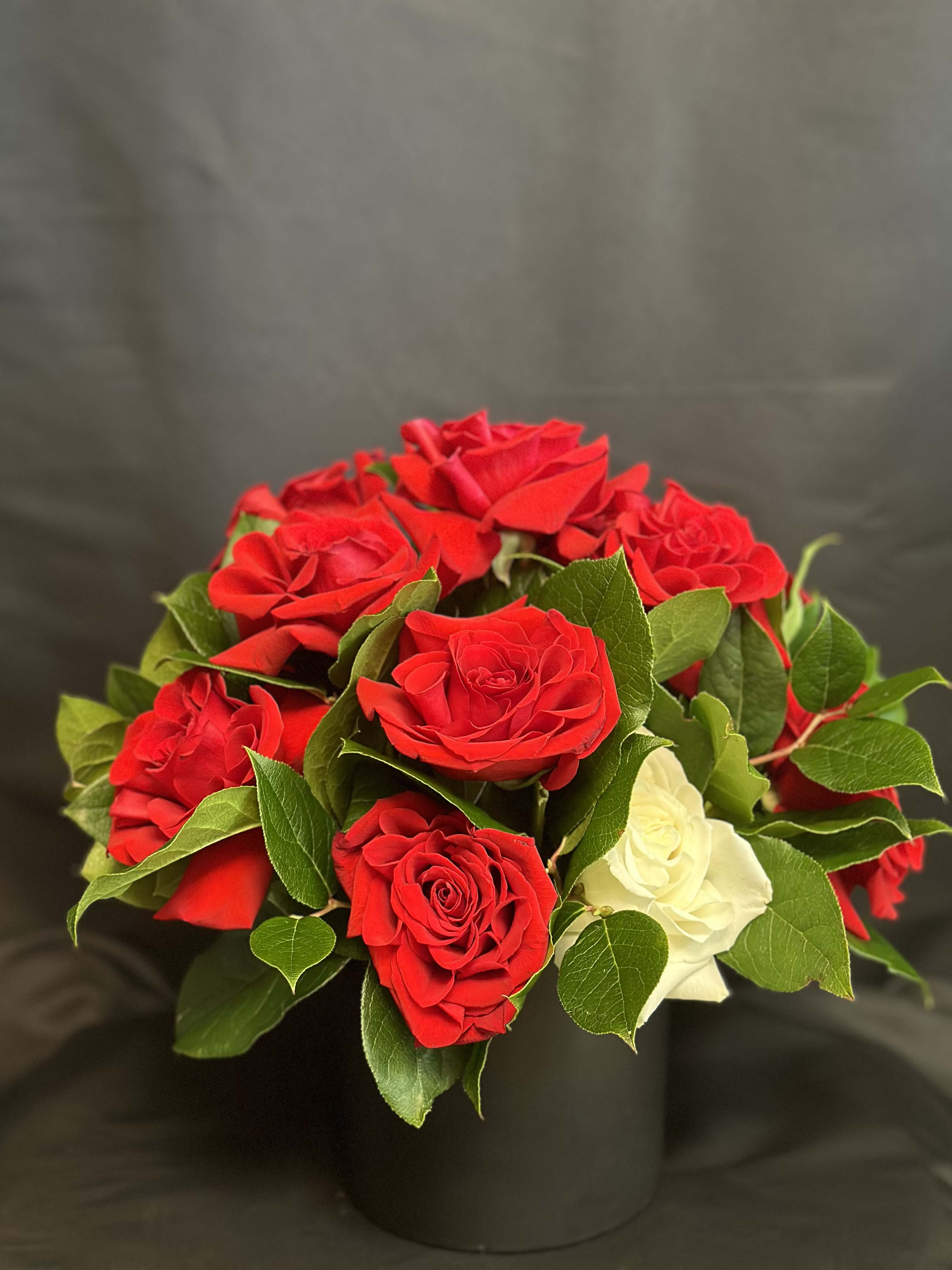 Red and white roses arranged in a black vase
