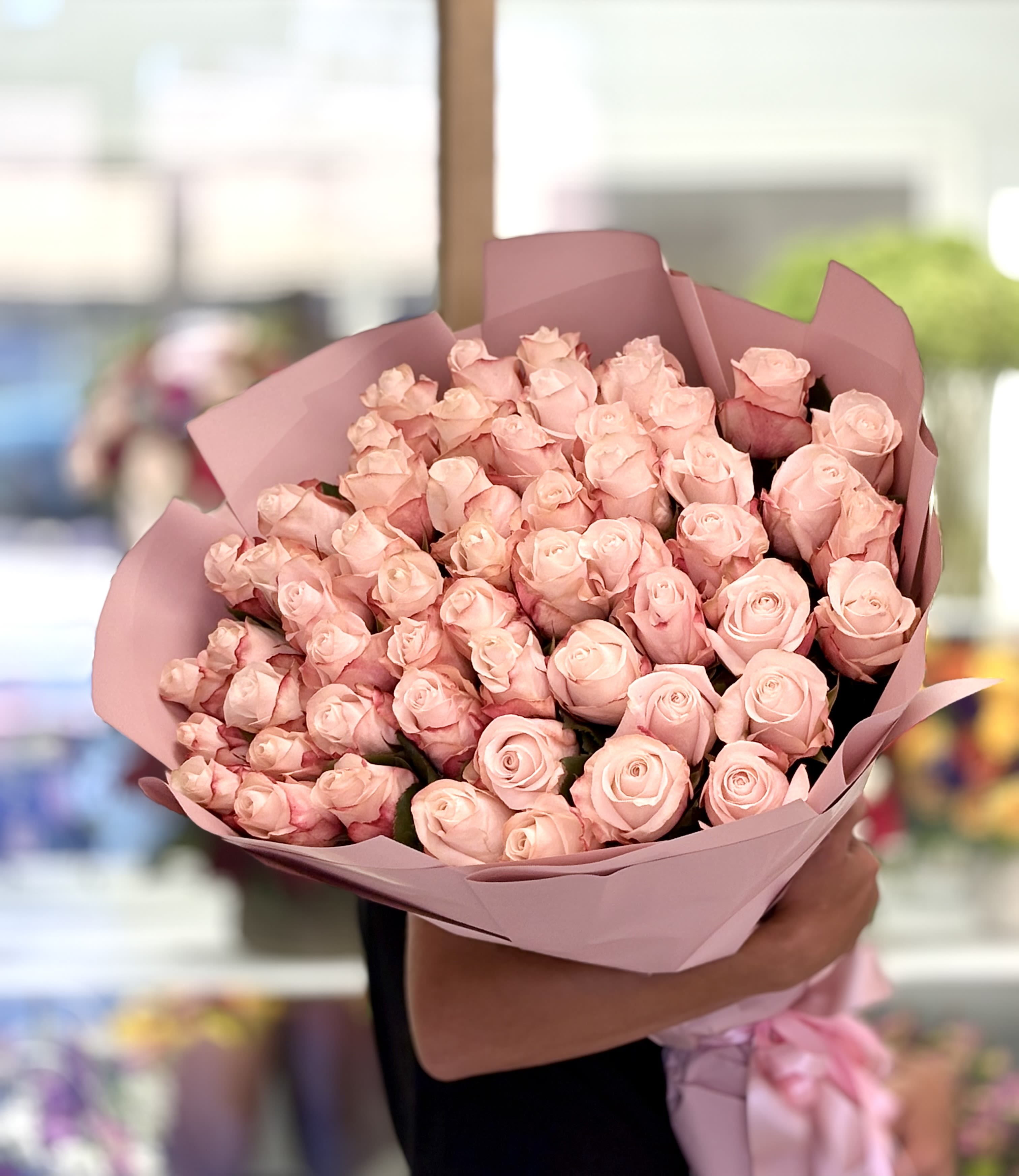 Large bouquet of pale pink roses wrapped in pink paper